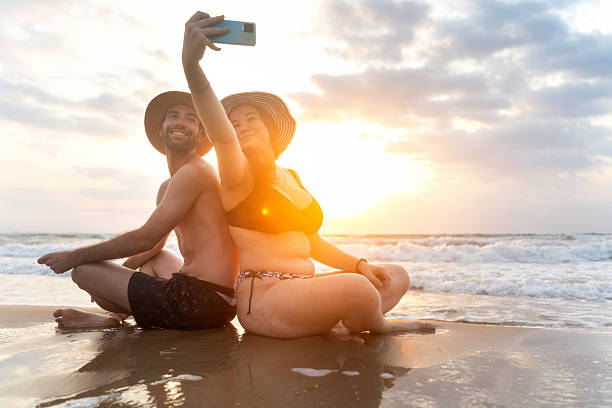 istock Couple taking selfie on beach at sunrise while meditating 2224131514