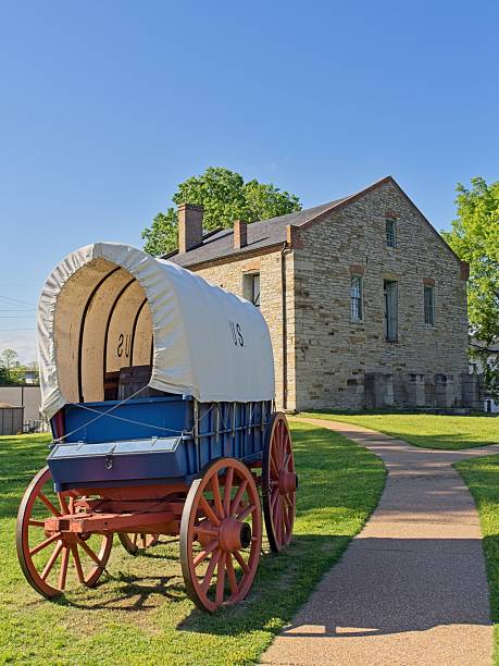 Fort Smith, Arkansas - USA, May 7, 2025. Fort Smith National Historic Site commissary and covered wagon. Stone commissary now containing interpretive displays of the old west and the purpose of the fort during the Indian wars in the late 19th century. Fort grounds with military canons.