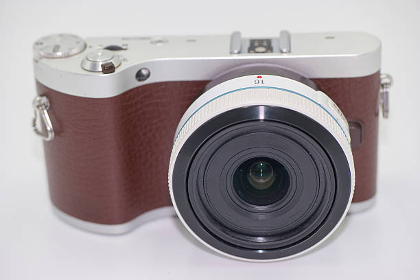 A black compact digital camera with an extended silver optical zoom lens, set against a dark, plain background.