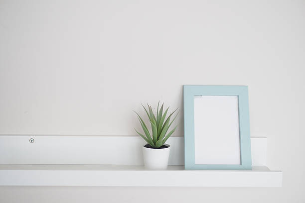 istock Simple decor with potted plant and empty picture frame on shelf 2224133422