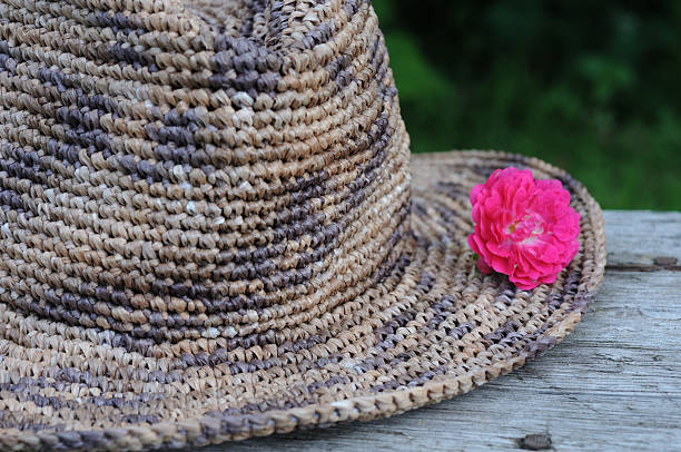 istock Straw hat with pink rose on a wooden background. 2224137673
