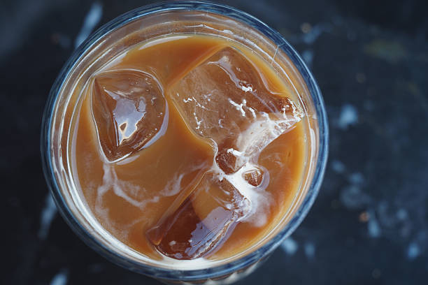 A refreshing iced coffee served in a clear glass with ice cubes.