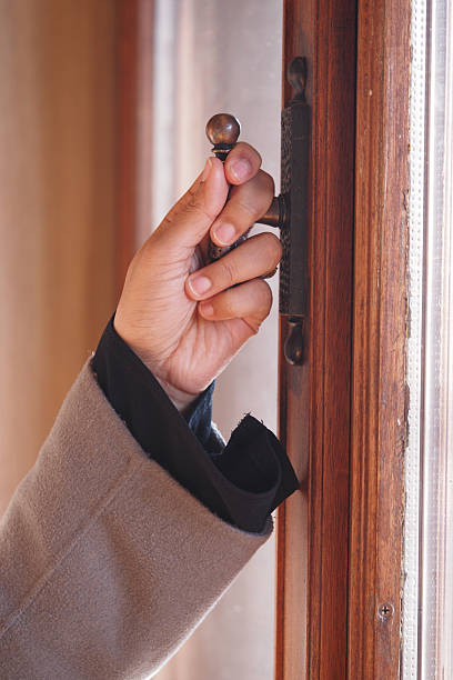 istock Hand grasping a vintage door handle in a cozy interior 2224139246