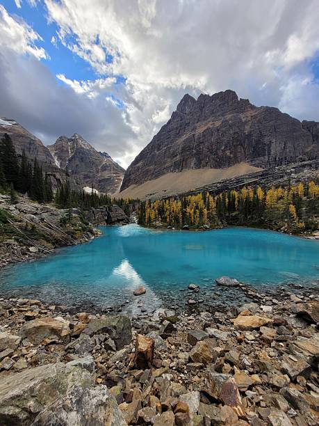 istock Glacier-Fed Alpine Lake with Golden Larches and Mountain Backdrop 2224142488