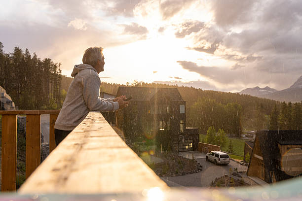 View down wooden deck railing to mature man at sunrise