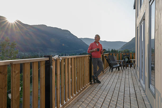 istock View down cabin deck to mature man watching sunrise 2224143584