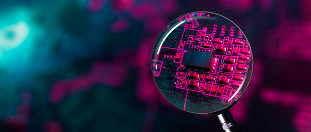 istock Close-up of computer electronic circuit microchips focused by a magnifying glass with neon colors 2224144134