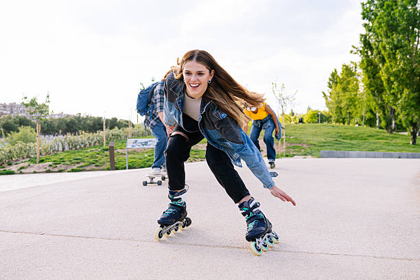 istock Young woman roller skating with friends in a park 2224147320