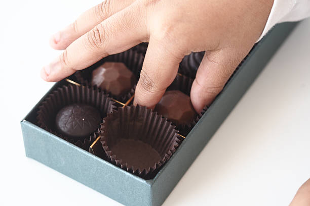 A refined selection of pralines and truffles showcases artistic designs and rich flavors. Perfectly arranged in gold packaging, each piece invites a sweet experience of luxury and joy.