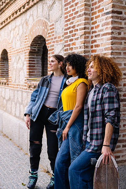 istock Young people leaning against brick wall looking up and smiling 2224148904