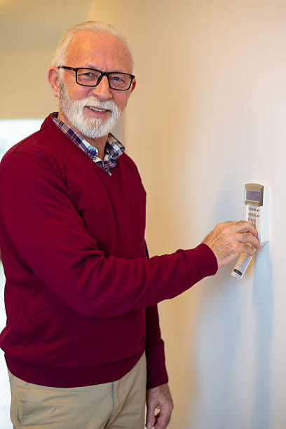 istock Smiling senior man setting up home alarm system 2224152507