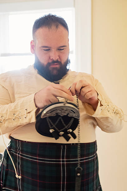 istock Millennial non-binary person getting dress in kilt for wedding. 2224158351