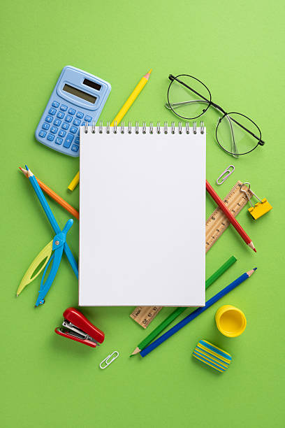 istock Various vertical colorful school supplies surround a blank notebook on a green background. The arrangement inspires creativity, perfect for ideas related to education, study, and school projects 2224158462