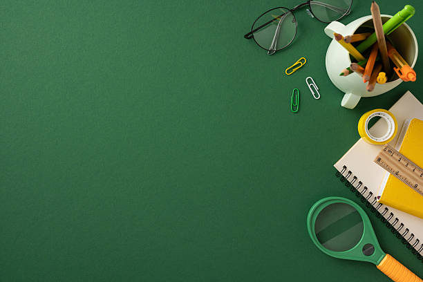 Back to school themed composition with school supplies placed neatly on a green workspace