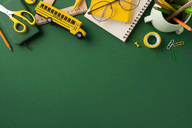 istock Various school stationery items, including notebooks, scissors, and a school bus toy, organized on a green background 2224158477
