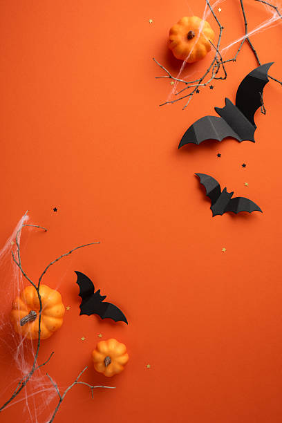 istock Halloween vertical composition featuring pumpkins, black paper bats, spider decorations on orange background, concepts of autumn, spooky atmosphere, seasonal festivities, and creative decoration 2224158494