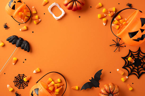 istock Halloween-themed items including candy corn, pumpkins, bats, spider webs, and jack-o'-lanterns arranged creatively on an orange background for a festive holiday theme 2224158500