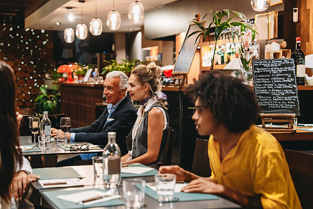 istock Group of colleagues enjoying dinner together at a restaurant 2224164616