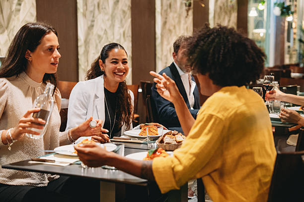 istock Group of colleagues enjoying dinner together at a restaurant 2224164832