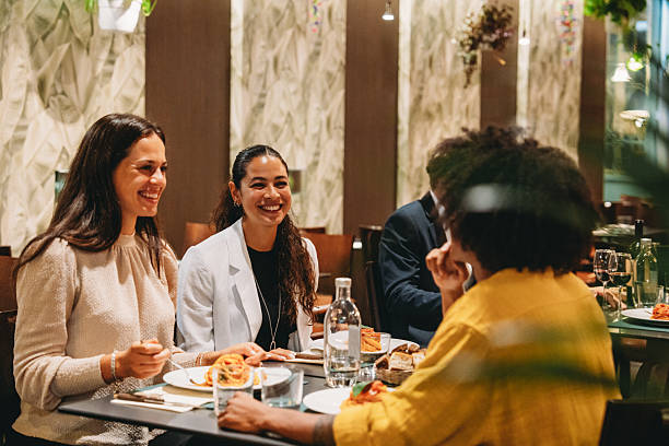 istock Colleagues enjoying dinner together at restaurant talking and smiling 2224164891