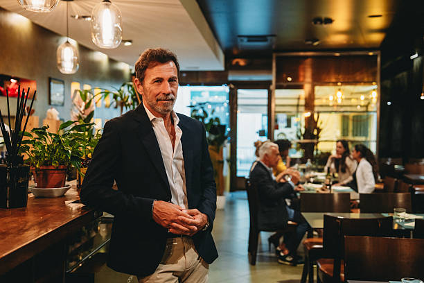 istock Restaurant manager posing in his restaurant while clients are dining 2224165124