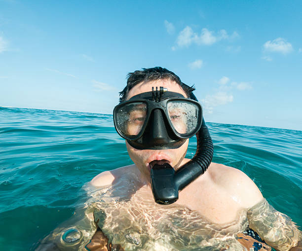 istock man snorkeling in blue ocean water with action camera 2224172323