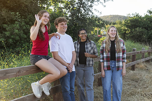 istock Young friend group sitting on a fence and chatting 2224172994
