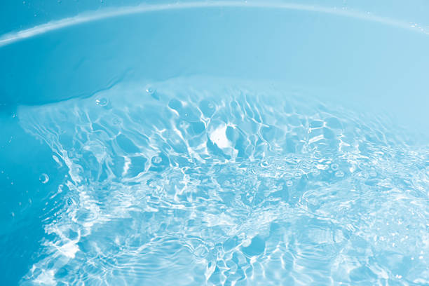 istock Blue water with ripples on the surface. Defocus blurred transparent blue colored clear calm water surface texture with splashes and bubbles. Water waves with shining pattern texture background. 2224174770