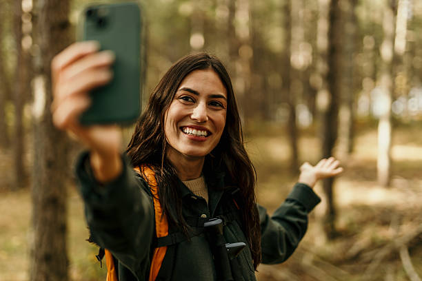 istock Smiling hiker taking a selfie while hiking in a forest 2224174823