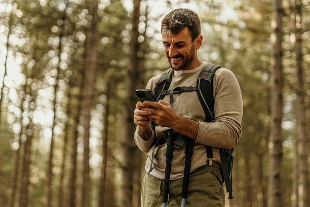 istock Smiling male hiker using smartphone in forest 2224174827