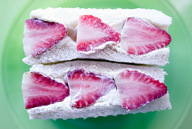 Fruit sandwiches (furūtsu sando in Japanese) are a delightfully light, sweet, and visually charming treat from Japan. These are sandwiches made with soft white bread (Japanese milk bread) filled with fresh seasonal fruit like strawberries, kiwi, mango, or grapes and a thick, fluffy layer of lightly sweetened whipped cream.They’re often cut in a way that displays the fruit beautifully, especially in triangles or squares with the fruit in full cross-section - picture-perfect.