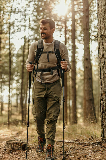 istock Smiling male hiker walking through forest during daytime 2224174947