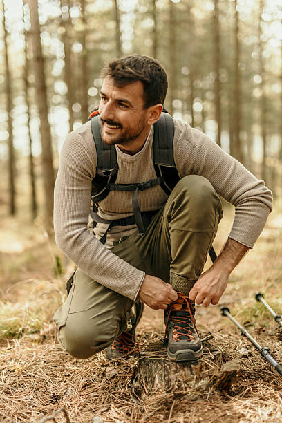 istock Hiker tying his boots while enjoying a trekking day in the woods 2224174948