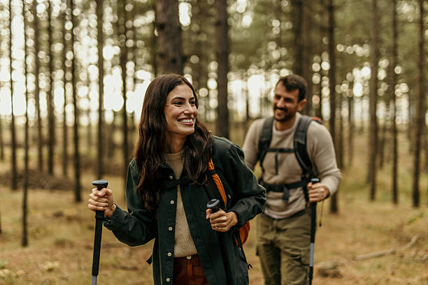istock Hikers walking through forest using hiking poles and backpacks 2224175064