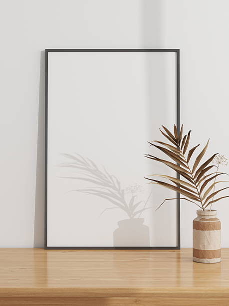 istock Vertical frame mockup on a wooden table decorated with an ornamental plant 2224178361