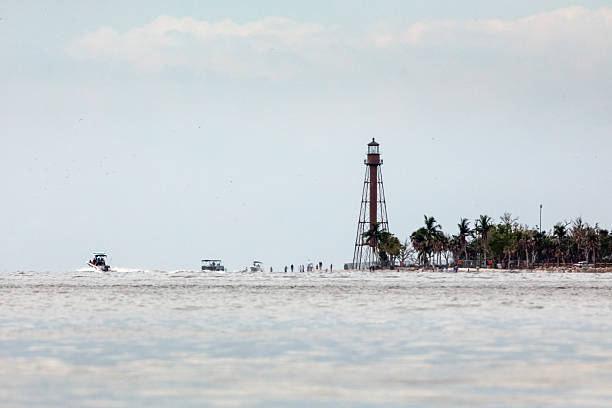 Sanibel lighthouse, Sanibel Island, Florida, photographed in early October 2023, image shows lighthouse much closer to the water in the gulf.  Hurricane Ian damaged the lighthouse but left it standing.  The small buildings that were once on the lighthouse grounds were totally destroyed and no longer exist.  The lighthouse was, at one time, standing quite some distance away from the beach and the gulf but now the beach is at the foot of the structure.
