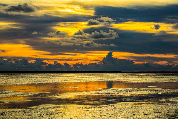 Orange sky reflecting in the water, sunset at Pineland, Florida, a small community in the southwest part of the state in Lee County and near Fort Myers.  Though tourists often avoid Florida this time of year, the sunsets during the summer months are spectacular.