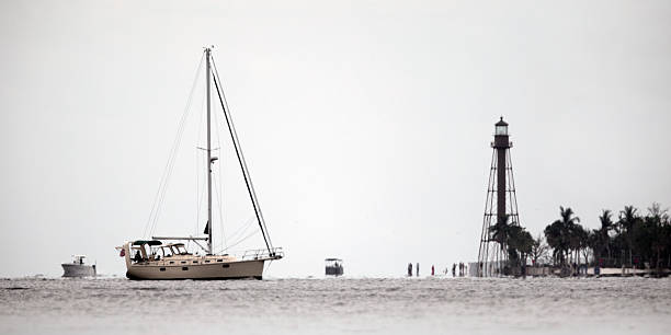 On a cloudy morning, a 45-year-old woman runs for pleasure and for her health on the jetty. She is wearing blue clothes and a cap, her hair is curly and blond.