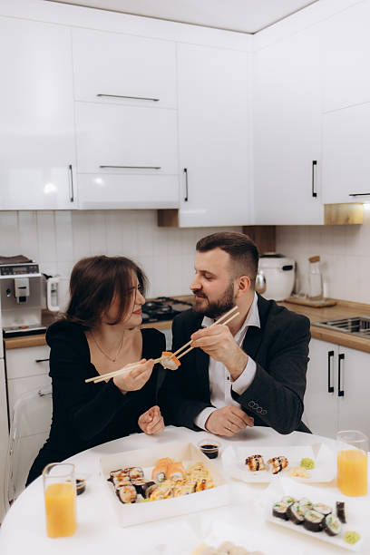istock Couple Sharing Sushi Together in a Modern Kitchen Interior 2224182562