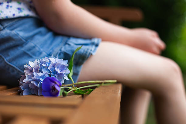 Young girl sitting on bench with summer flowers in Seattle, Washington, United States