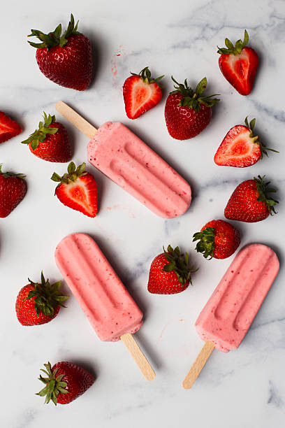 istock Strawberry ice pops on marble counter with fresh berries 2224186095