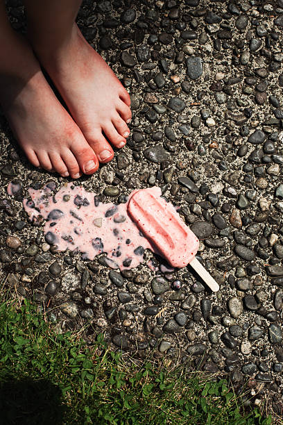 istock Child's feet standing by melted popsicle 2224186096