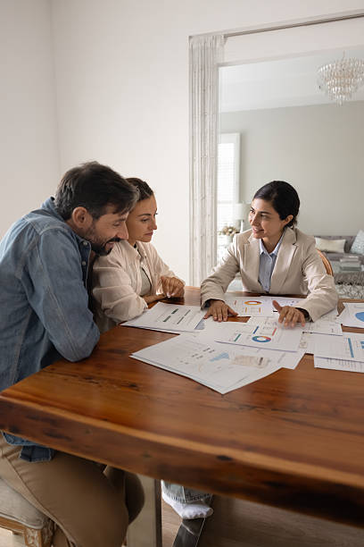 istock Young Indian agent offering insurance program to couple of client 2224192253