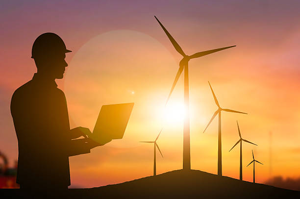 istock Engineering holding laptop wind turbine sunset 2224193551