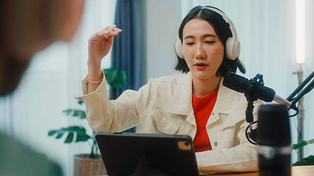 istock Generation Z podcasters collaborating wearing headphones discussing topics during recording session together in home studio. 2224193588