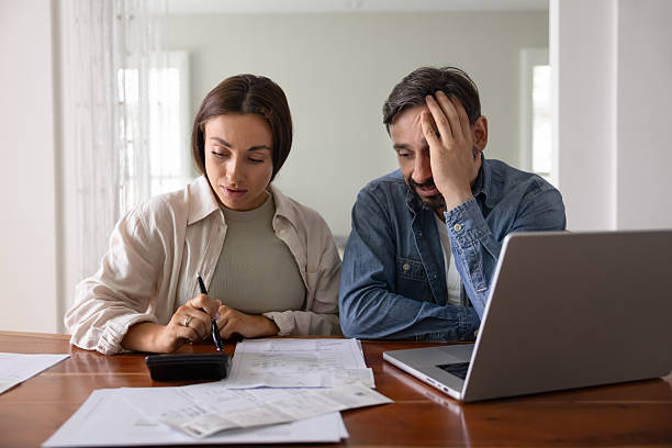 istock Concerned young middle aged couple counting expenses 2224193821
