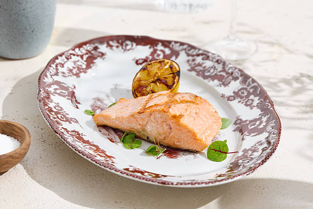 istock Grilled salmon steak with charred lemon, bright daylight, overhead composition 2224193933