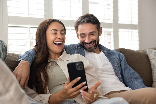 istock Cheerful Hispanic couple watching funny content on mobile phone 2224194193