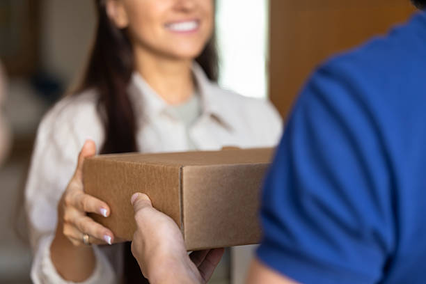 istock Female customer taking parcel from delivery logistic service worker man 2224196006