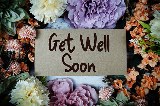 istock Get well Soon typography text with flower decorated on wooden background 2224197937
